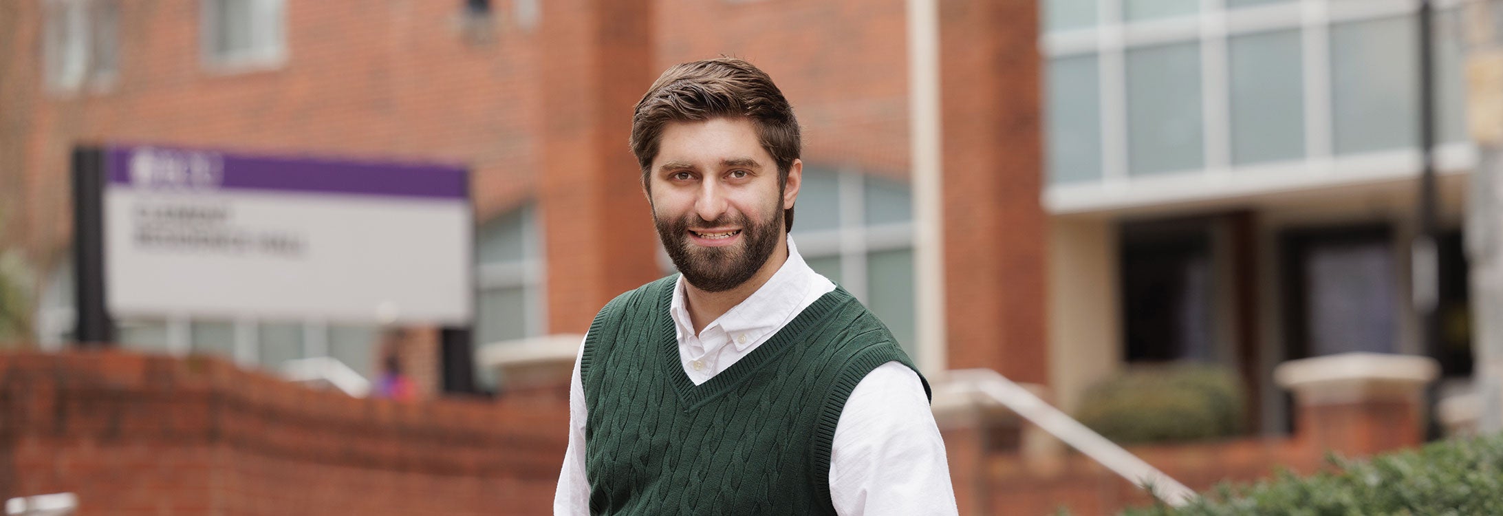 A bearded man in a green sweater.