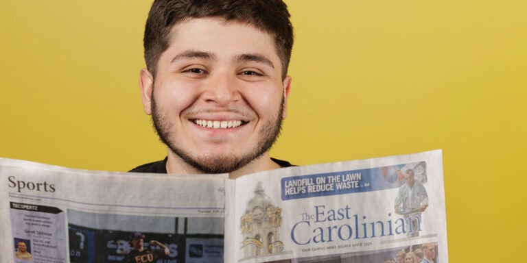 A man reads the East Carolinian newspaper