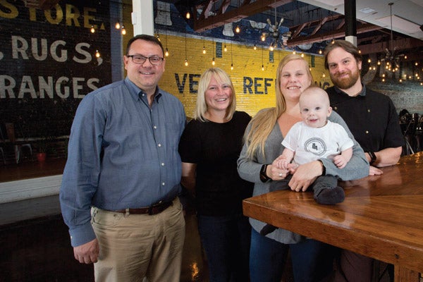 From left, Brad Hufford ‘00, Kristi Southern ’99, Tandi Wilson ’04 and Jacob Wilson along with their son, Marion Bruce Wilson, pose at the Dickinson Avenue Public House restaurant on Dickinson Avenue. Menu items include Korean barbecue beef fries and smoked brisket mac and cheese. 