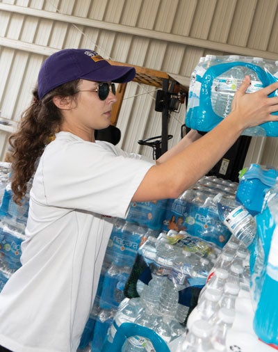 Medical student Hayley Stowe stacks water bottles in Duplin County as part of an ECU relief effort following the hurricane.