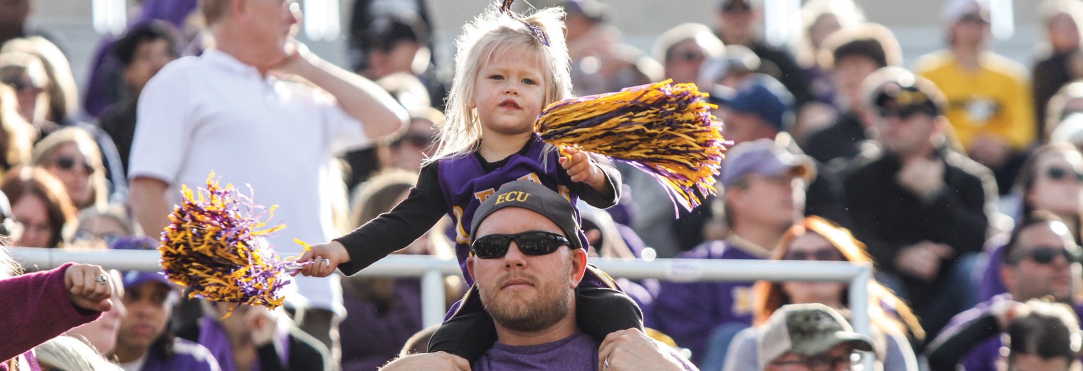 Fans dressed in ECU merchandise at a game.