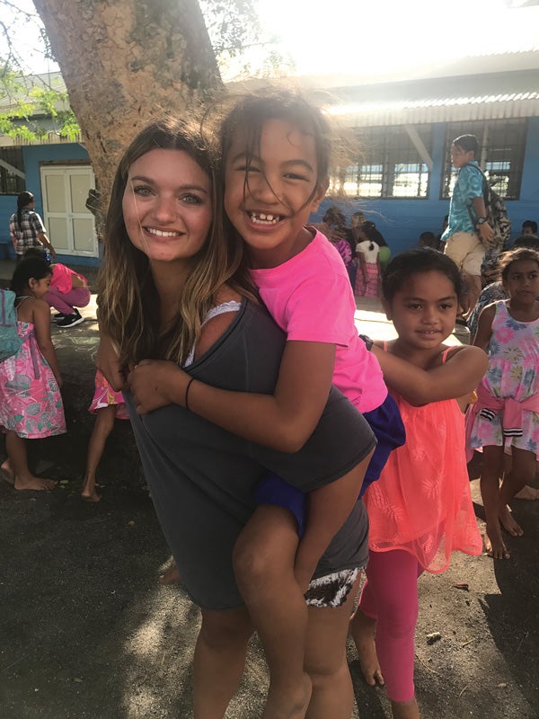 Senior psychology major Haley Jamrog is shown with children at the Avarua Primary School in Rarotonga, Cook Islands.
