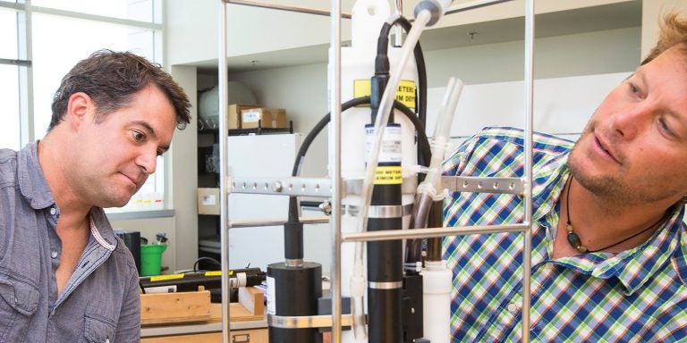 ECU geology professors J.P. Walsh, left, and Reide Corbett work with an instrument in a lab at the University of North Carolina Coastal Studies Institute.