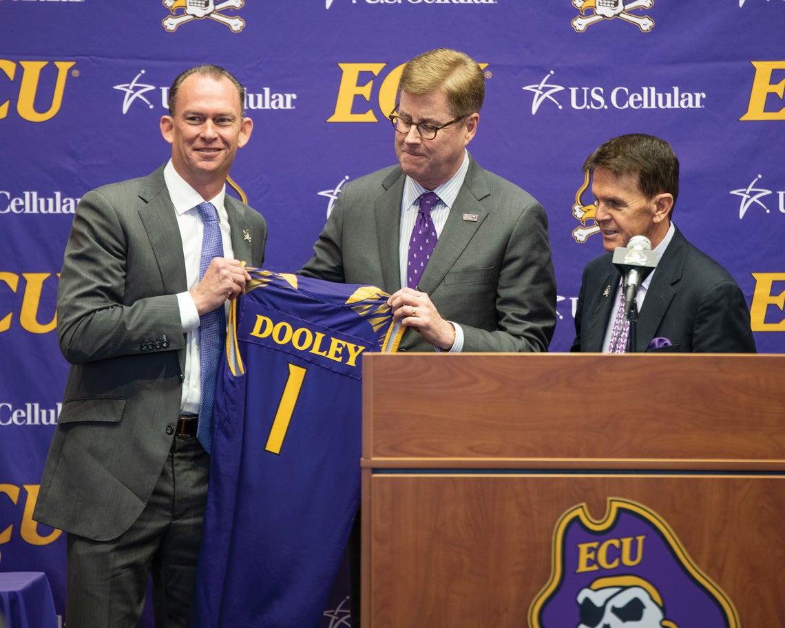 From left, Dooley, ECU Chancellor Cecil Staton and Dave Hart, special advisor for athletics, pose at the April 4 news conference to announce Dooley’s return to Greenville.