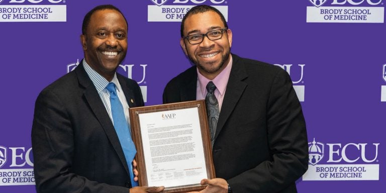 Dr. Gary L. LeRoy, president-elect of the American Academy of Family Physicians, left, presents Dr. Kendall Campbell, interim senior associate dean for academic affairs at the Brody School of Medicine, an award in November celebrating Brody’s track record of producing family physicians.