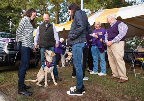 Carlton and Meghan Blanton bring future guide dogs to ECU football games to help train them to assist people with vision loss. Photos by Rhett Butler.