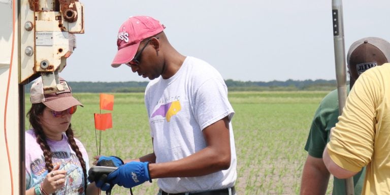 East Carolina University associate professor Alex Manda (center) takes samples in Hyde County with a team of graduate students to test soil conductivity as part of his research into saltwater intrusion. (Photo by Matt Smith)