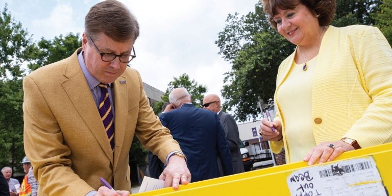 The Statons sign the final steel beam for the southside expansion of Dowdy-Ficklen Stadium.