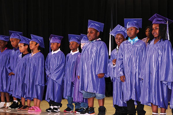 Students stand during the school’s first kindergarten graduation ceremony in June.