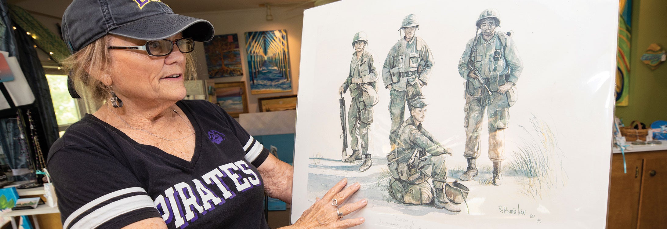 Sherry Thurston holds “Waiting,” which she
painted from a photo she took of Marines from the 24th Amphibious Unit at Camp Lejeune.