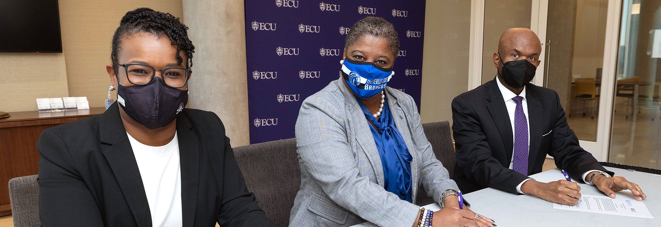 LaKesha Forbes, left, associate provost for equity and diversity at ECU; Monica Leach, provost and vice chancellor for academic affairs at Fayetteville State University; and Grant Hayes, interim provost and senior vice chancellor for academic affairs at ECU, sign a memorandum of agreement between the two universities on Oct. 15.