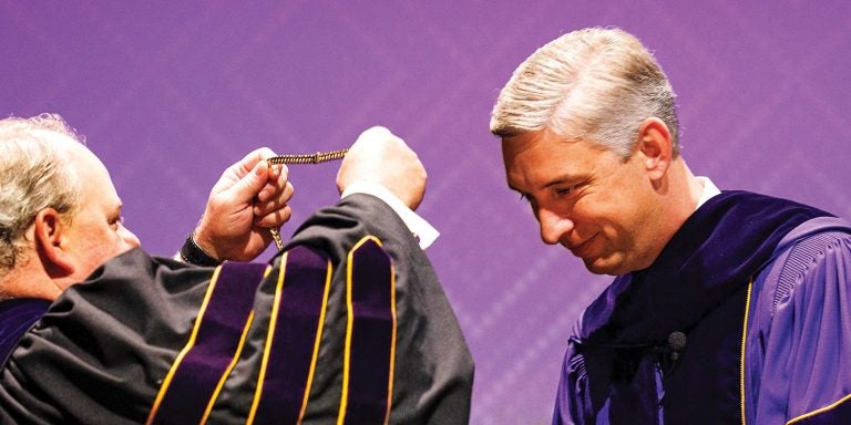Scott Shook, chair of the ECU board of trustees, puts the Chancellor’s Medallion on Chancellor Philip Rogers