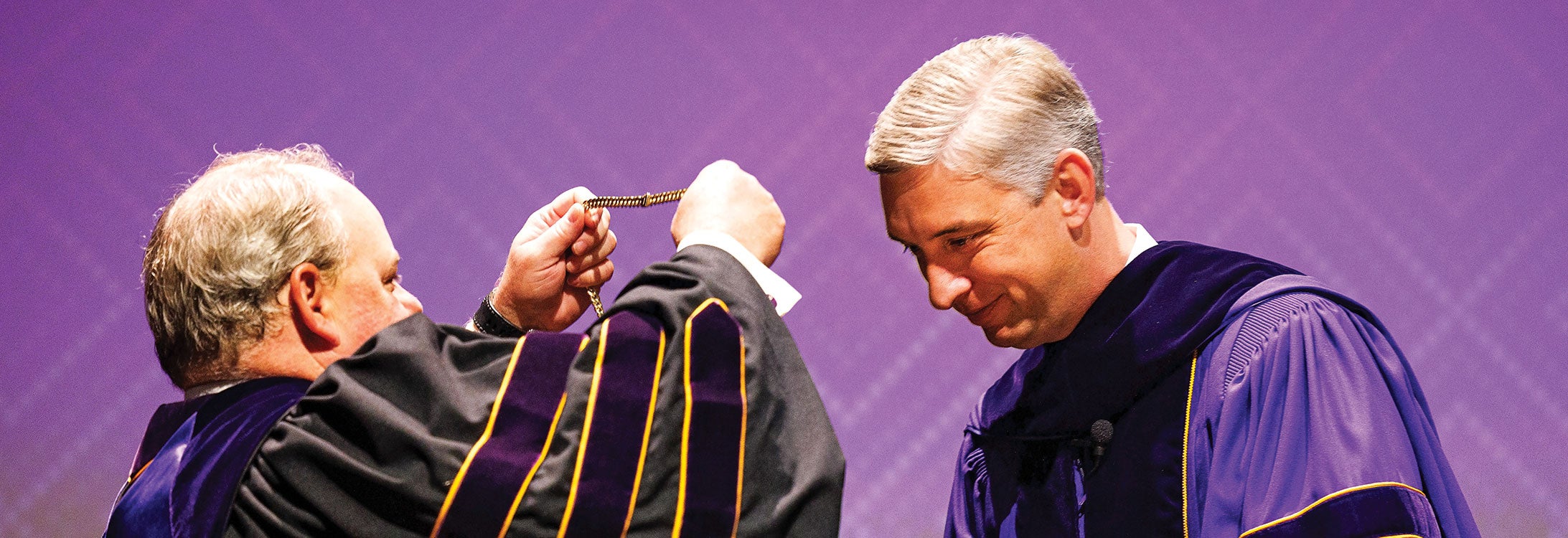 Scott Shook, chair of the ECU board of trustees, puts the Chancellor’s Medallion on Chancellor Philip Rogers