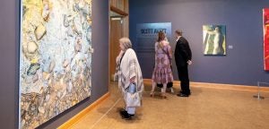 Patrons look at Scott Avett's artwork on the walls of the Greenville Museum of Art.