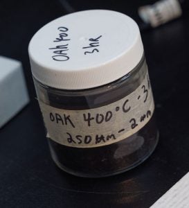 A small clear container with a white lid and label that reads: Oak 400 degrees Celsius 3 hours