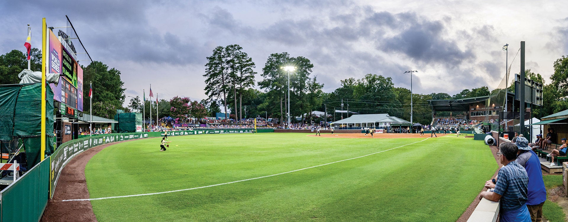 A vibrant baseball field bustling with players engaged in an exciting game under a clear blue sky.