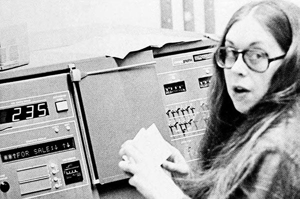 An old photo of a woman at an old computer
