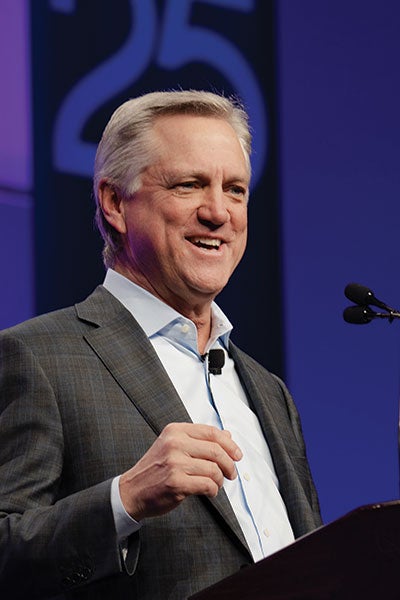 A man in a sports coat at a podium.