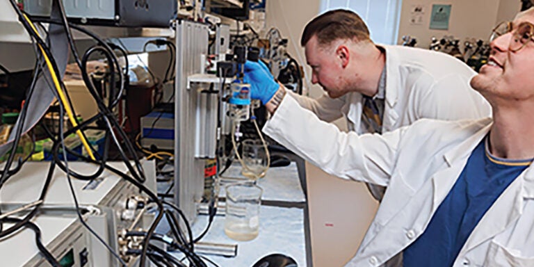 Doctoral candidates Everett Minchew, foreground, and Nick Williamson work in the Spangenburg Lab at ECU.