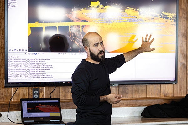 A man in black shows off a presentation.