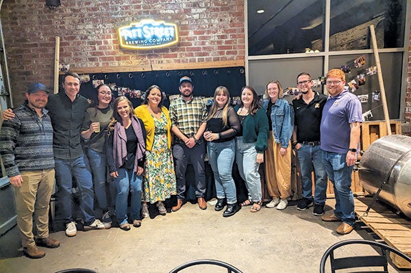 A group of people stand in a bar.