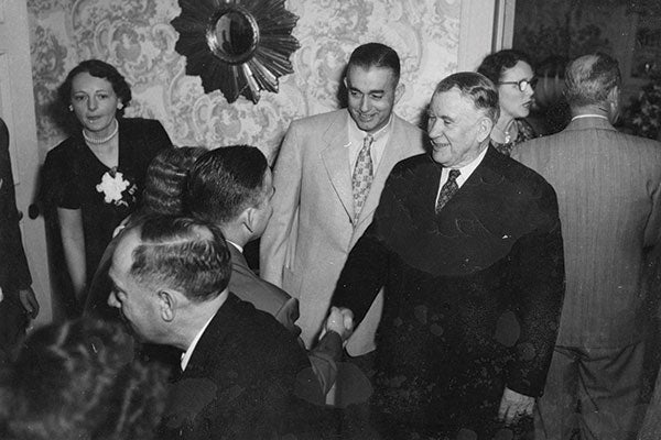 A group of men and one woman in a room.