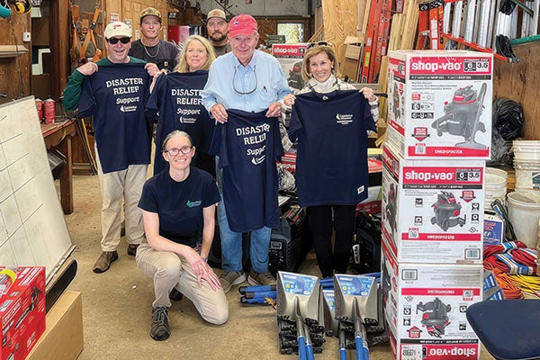A store's staff showing off t-shirts.